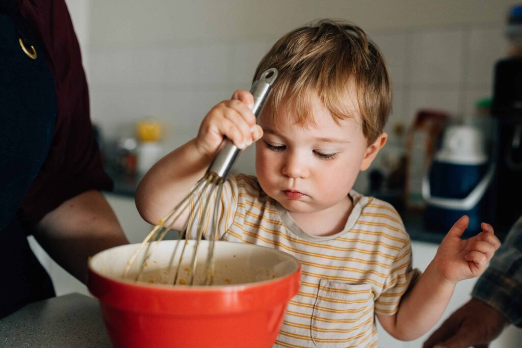 Boy stirring bowl with a whisk