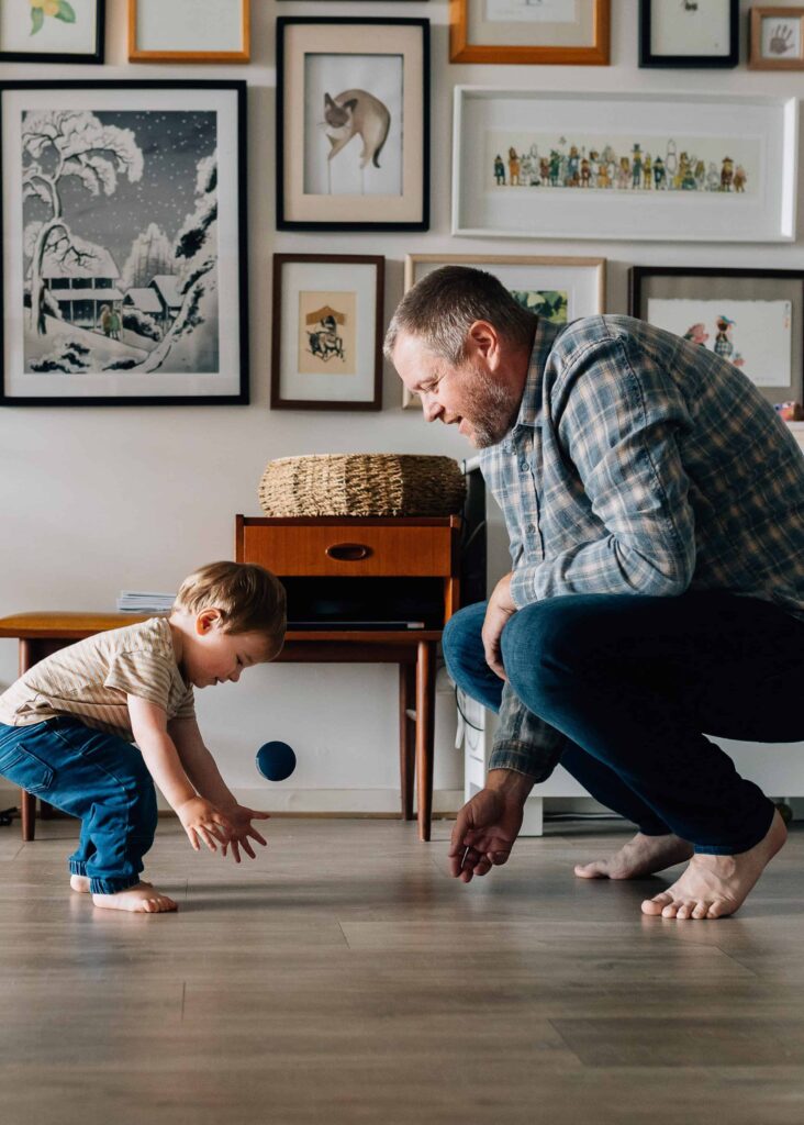 Dad and son playing with a ball, value of photography, especially plus size family photos